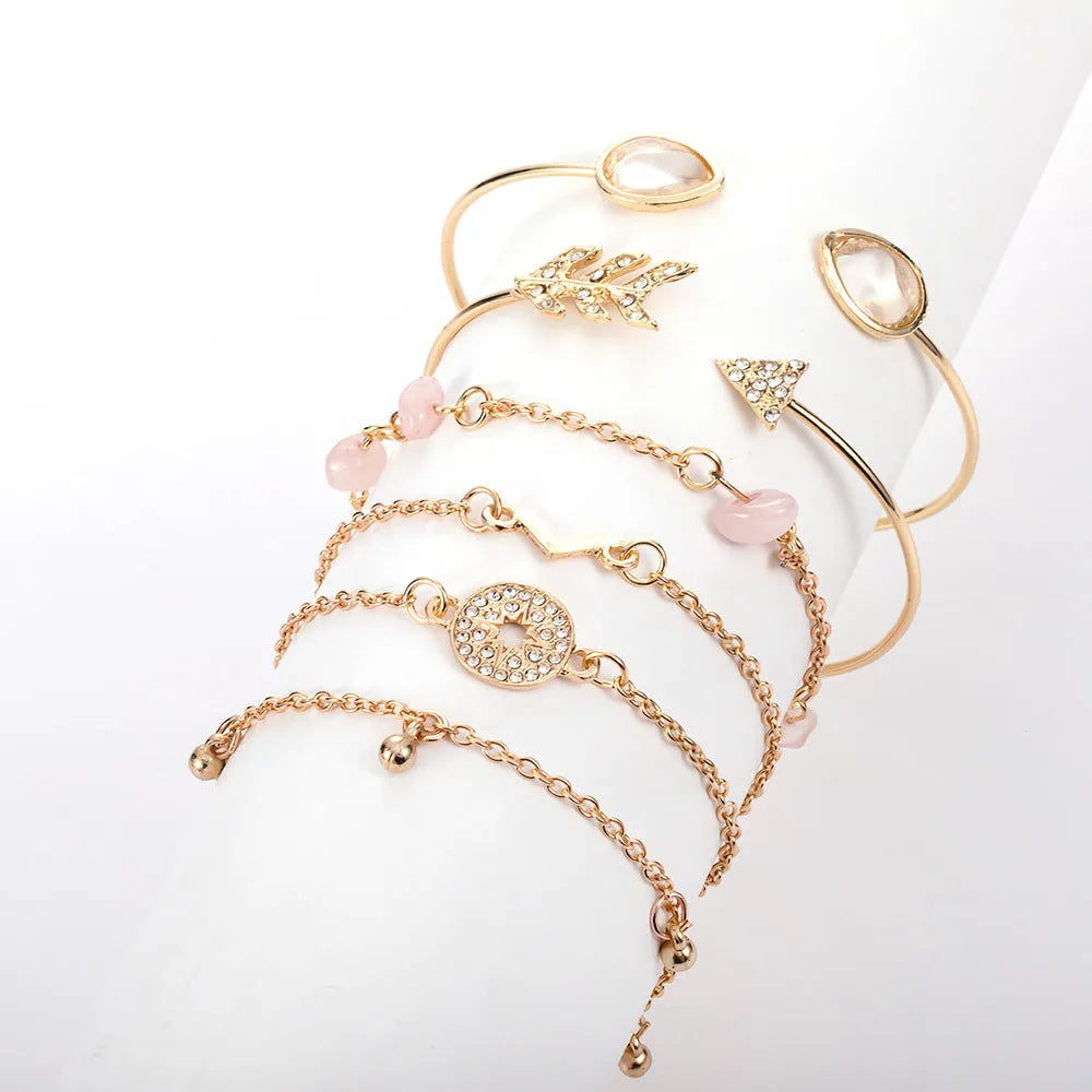 Set of six golden bracelets with arrow, water drop and V shapes featuring spot drill pattern.