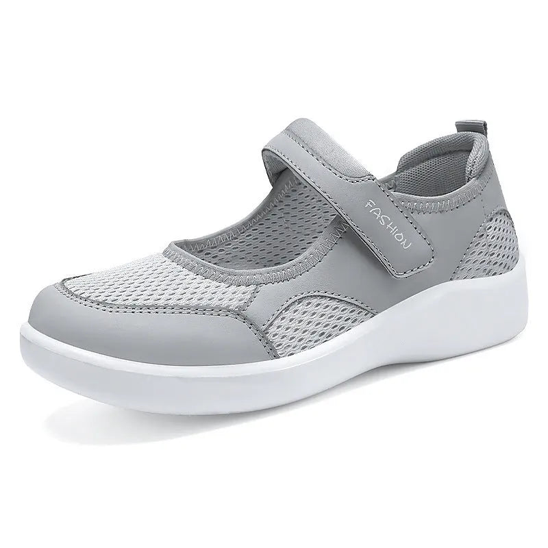 Women's low-top casual sneaker in grey mesh with velcro strap and flat polyurethane sole.