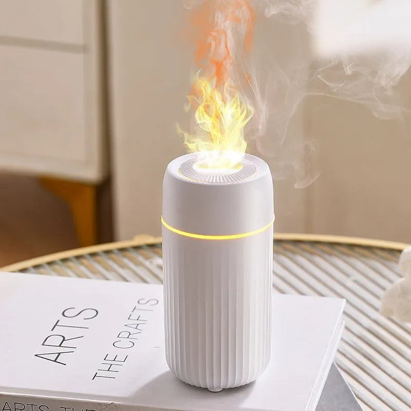 Black car aroma diffuser with simulation flame on a dashboard next to a cup holder.