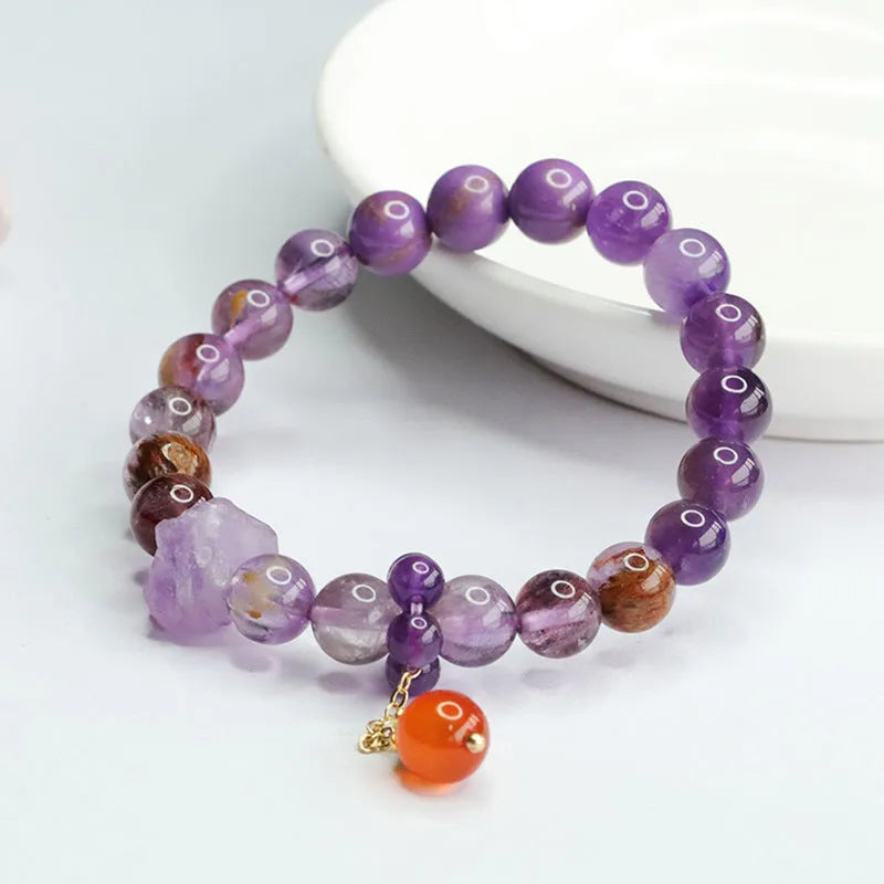 Close-up of a nine purple Fire Duobao and amethyst crystal bracelet with red agate stones, Mori style.