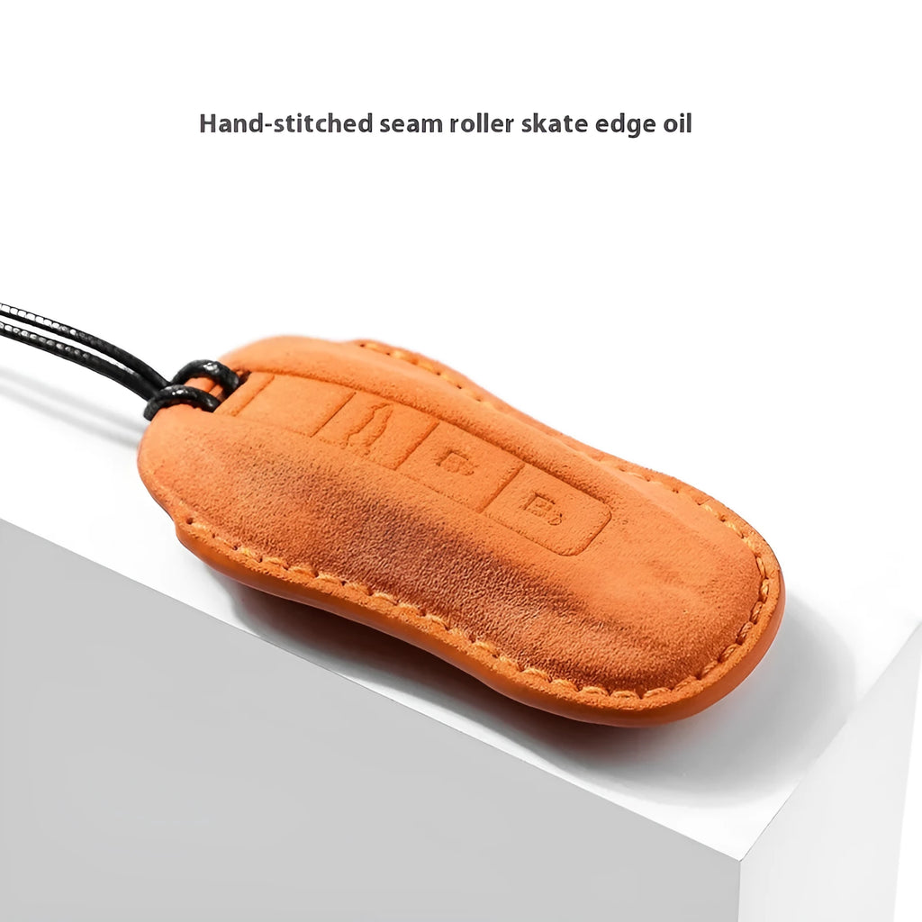 Suede car key cover shown in cement grey, dark green, light grey, and orange colour options.