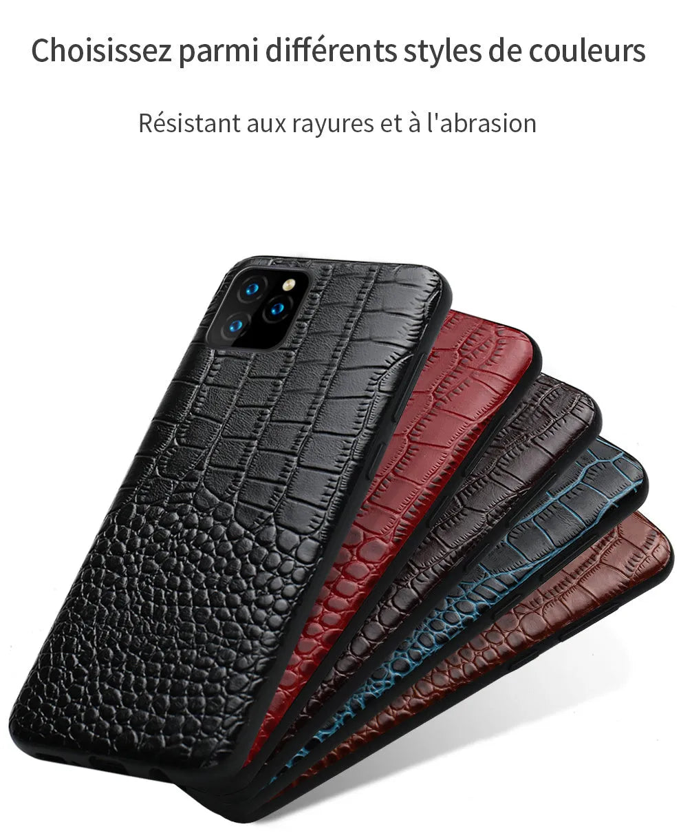 Handmade leather iPhone case with a crocodile pattern in multiple colours on a table.