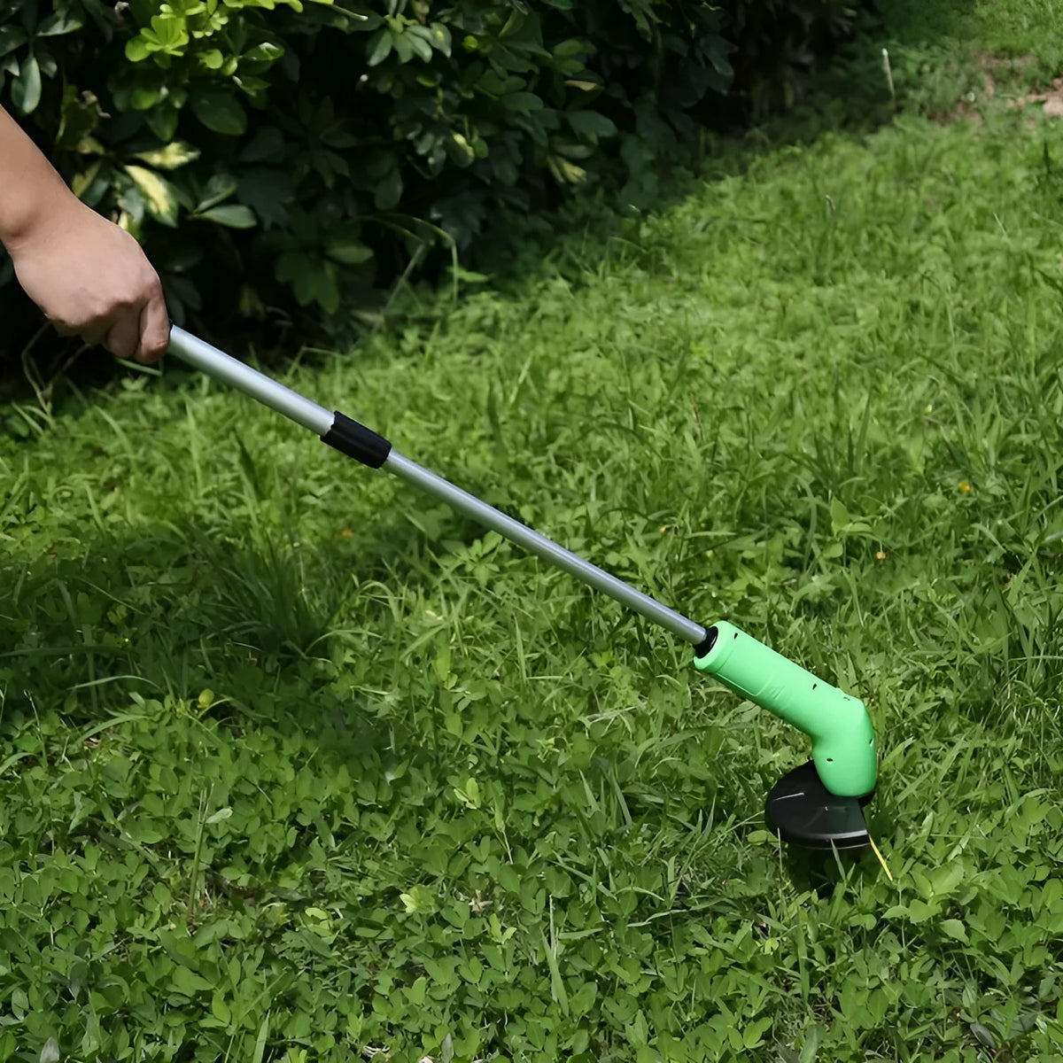 Cordless lawn trimmer with extension pole and protective shield for garden maintenance
