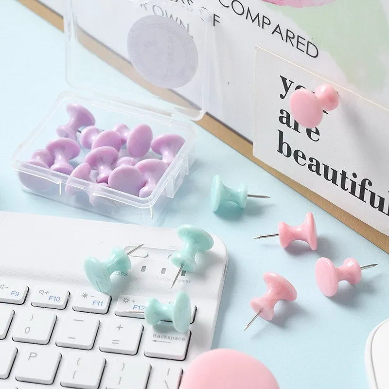 Plastic push pins in macaron colours: cherry blossom pink, mint green and lavender, displayed in small boxes.