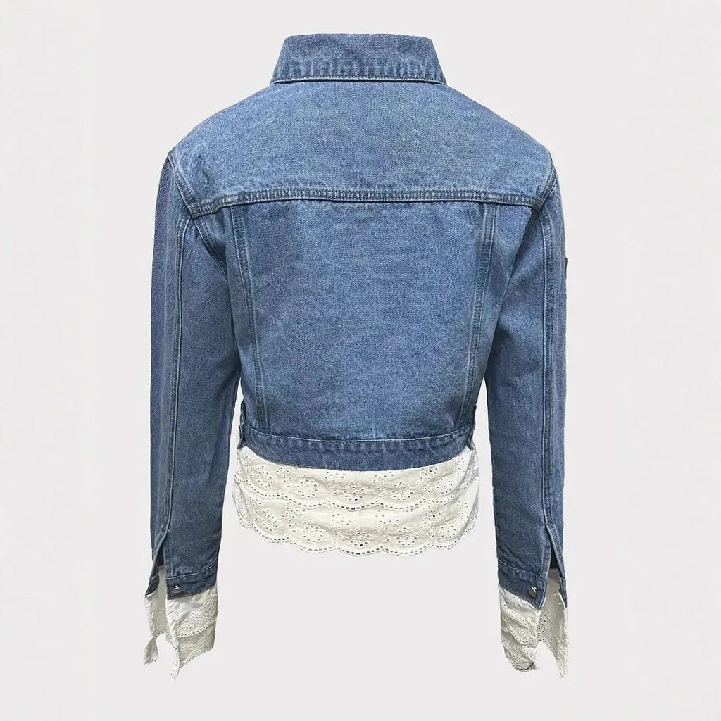 Blue women's denim jacket with decorative lace stitching detail on the front.