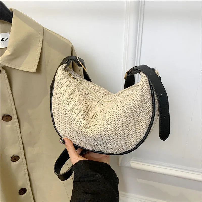 Women's knitted straw woven crossbody bag showing woven texture and internal phone/document compartments