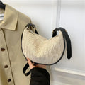 Women's knitted straw woven crossbody bag showing woven texture and internal phone/document compartments