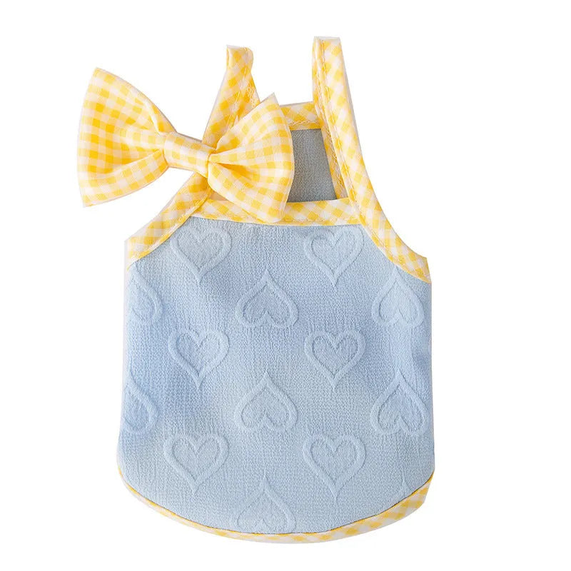 Small dog wearing a blue heart texture vest with bow suspenders and matching hairband