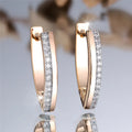 Geometric V-shaped champagne gold women's ear clips with white diamond accents.