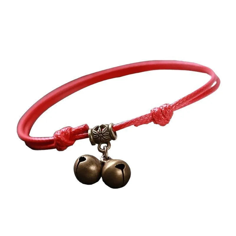 Black nylon rope dog collar with a small brass bell and an adjustable sliding fastener.