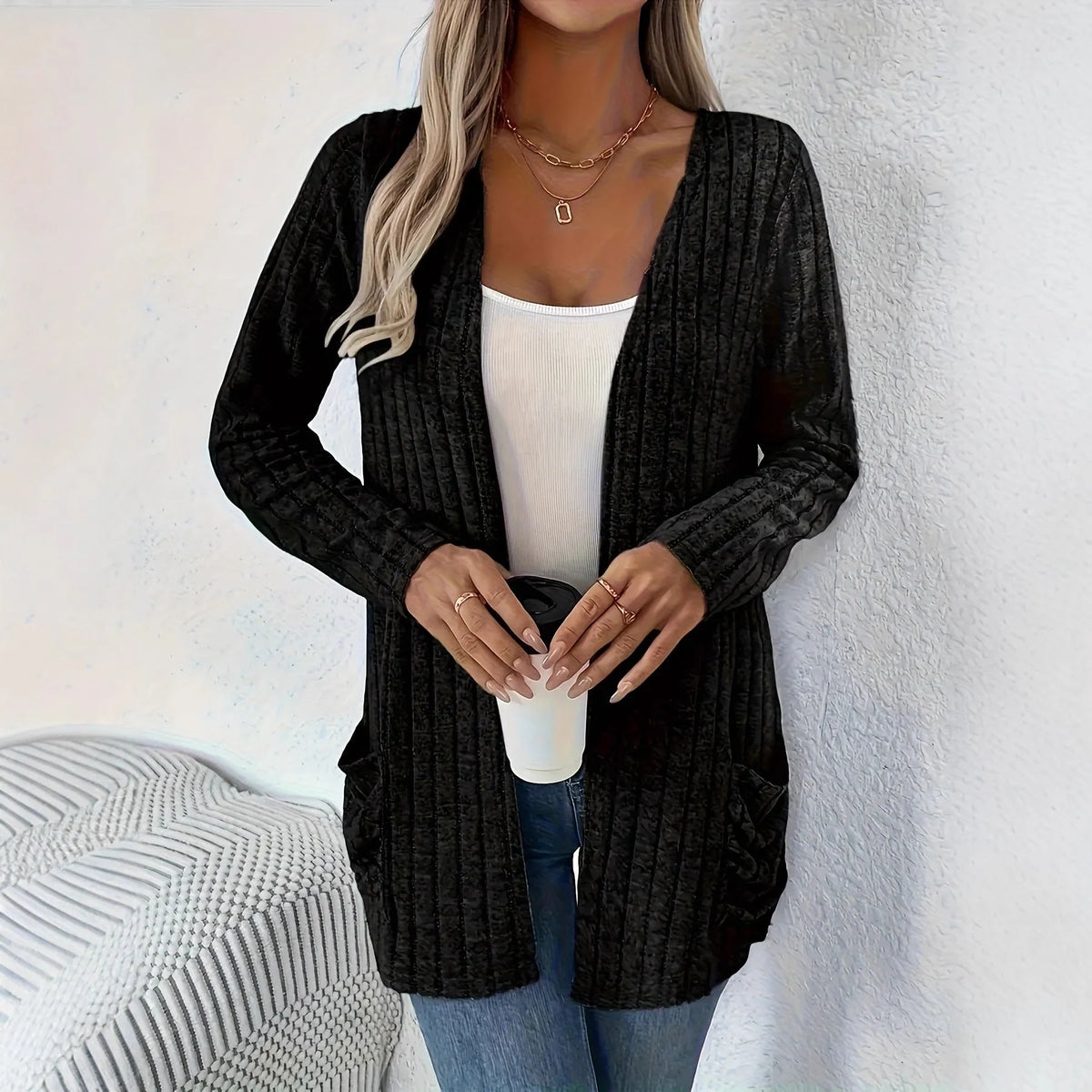 Loose fit grey cardigan with long sleeves and side pockets on a hanger.