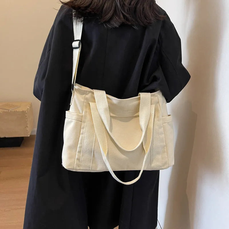 Large canvas shoulder bag for women in solid colour with external pocket and internal phone compartment