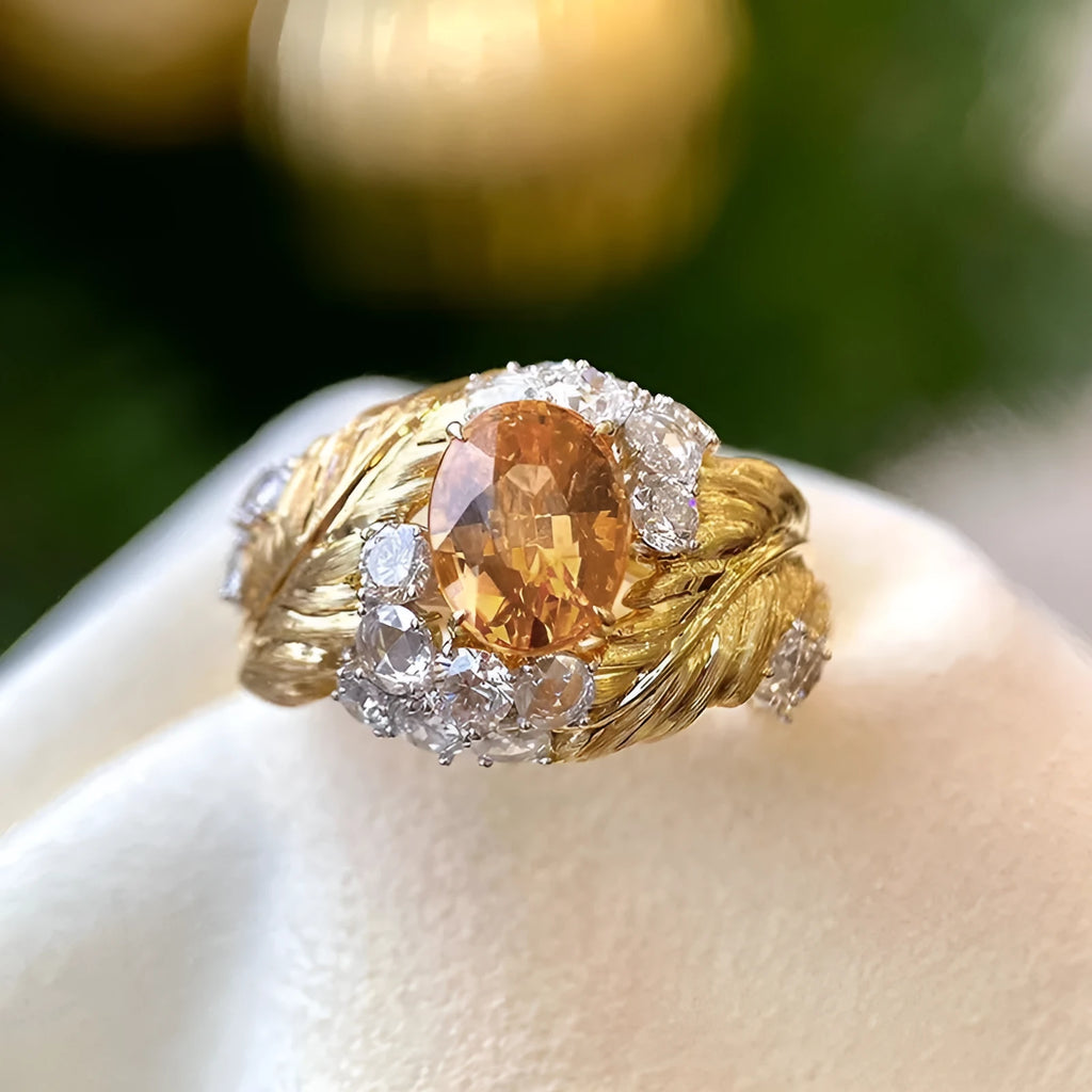 Gold-coloured women's ring with embossed feather pattern and yellow zircon gemstone