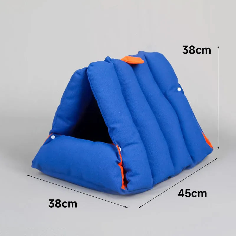 Blue triangular cat bed with drilled holes on a sofa, showing removable cotton cover.