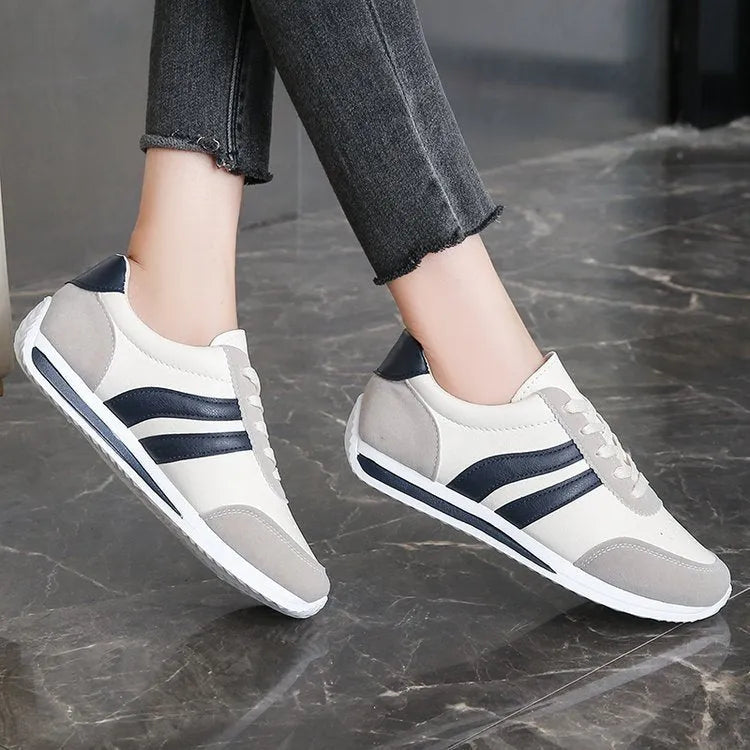 A pair of low-top red and blue lace-up running sneakers with a PU mesh upper and rubber sole on a white background.