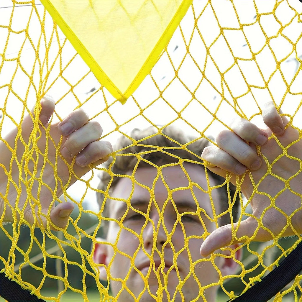 A portable black and yellow soccer training goal net with a steel frame set up on grass.