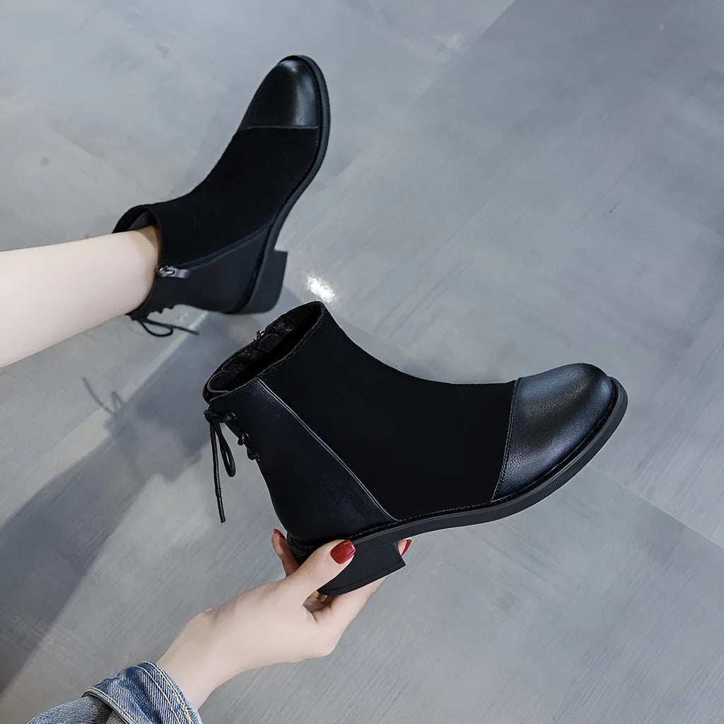 Black women's knee boots with side zip, round toe, short heel and decorative bow.