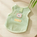 Blue knitted cat clothing with hollowed-out sections and a cartoon bear patch on the front.