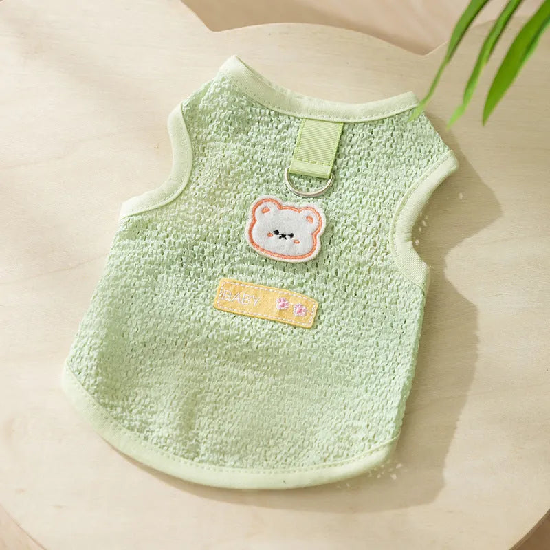 Blue knitted cat clothing with hollowed-out sections and a cartoon bear patch on the front.