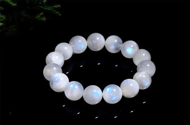 Natural blue polished moonstone round bead bracelet with adjustable clasp on a wrist.
