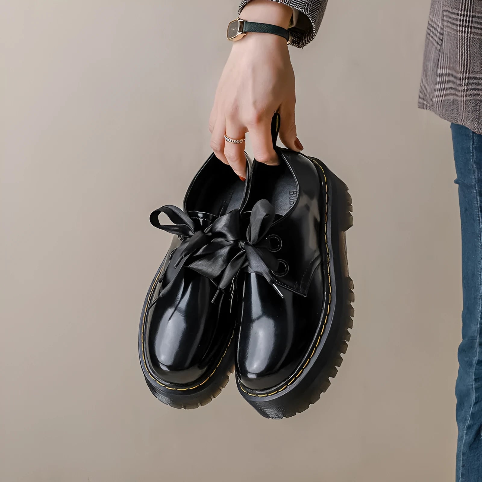 Women's black leather shoes with thick sole, cross strap, and ribbon lacing closure