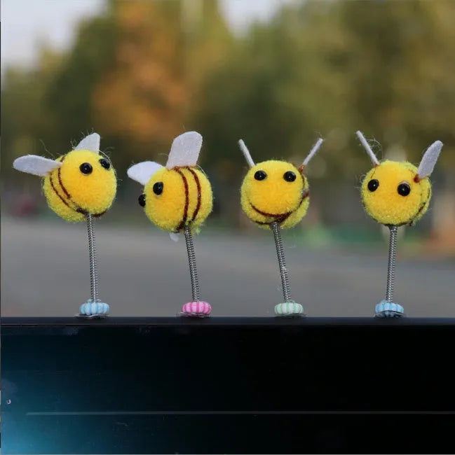 Small plush swing spring bee car decoration ornament on a 3cm scale grid.