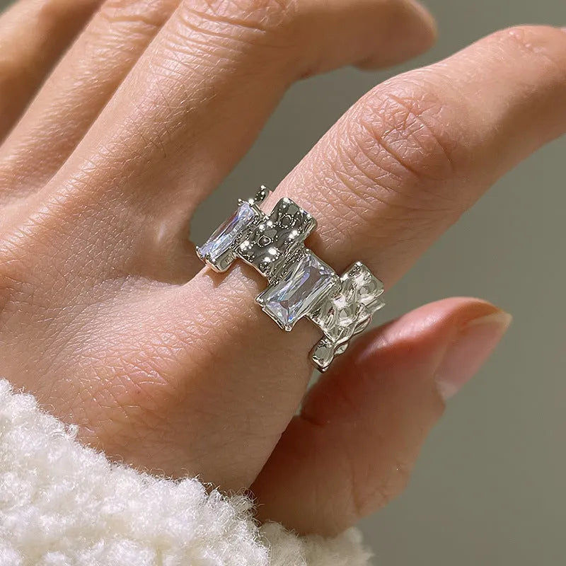Silver geometric cross ring with open gemstone setting and three-dimensional decoration