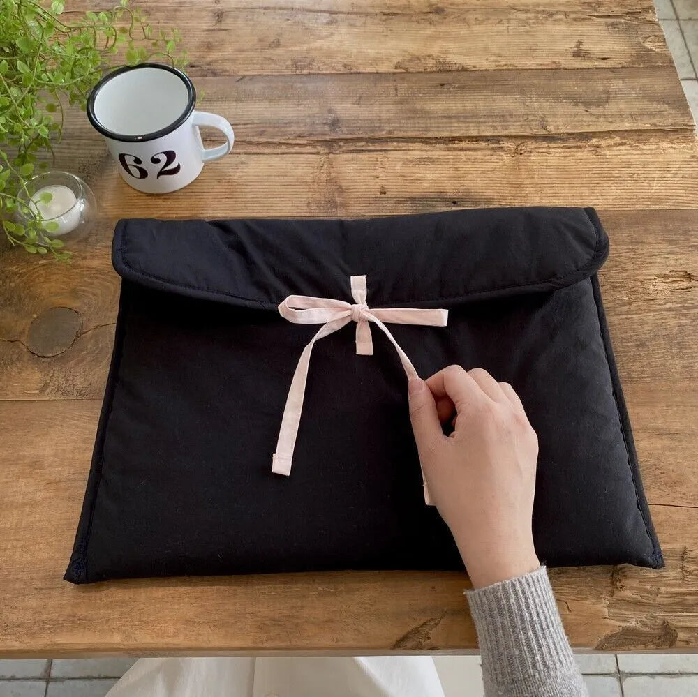 Women's black quilted computer bag with ballet bow and striped lining