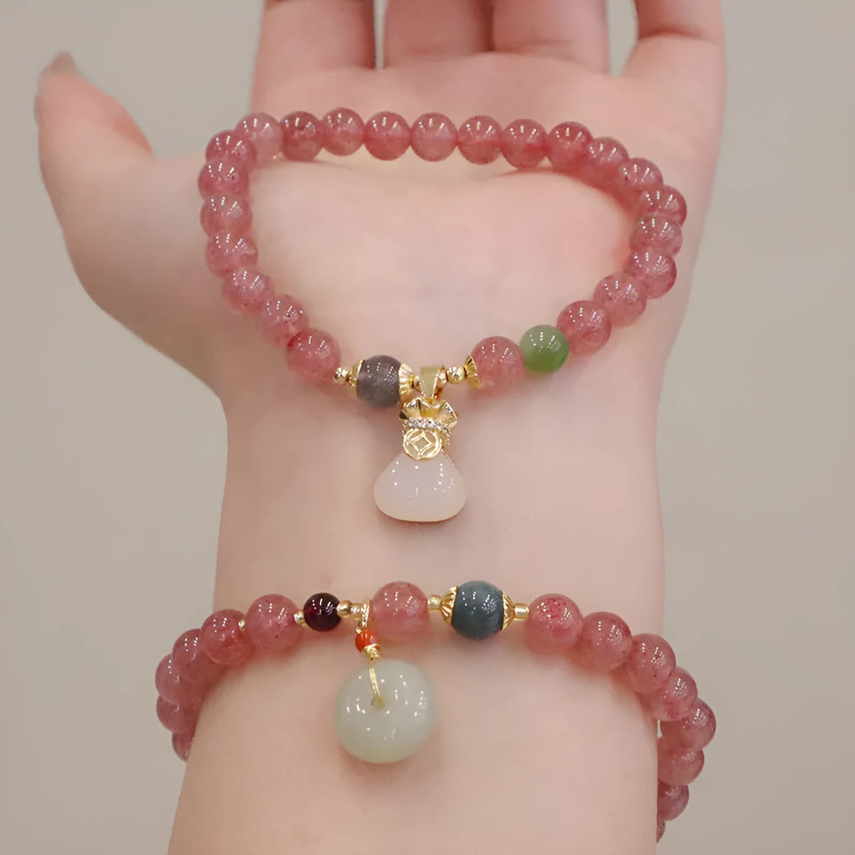 Women's strawberry quartz bracelet with geometric beads, peace buckle closure, and lucky bag charms