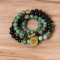 Green and black alloy bead elastic bracelet stretched on a wrist.