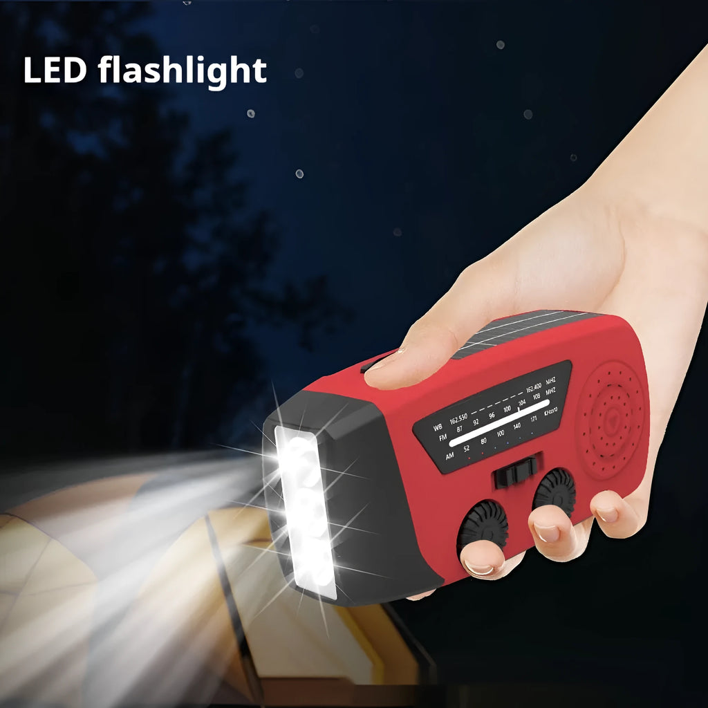 Red rechargeable emergency hand radio with built-in torch, showing compact size and wrist strap.