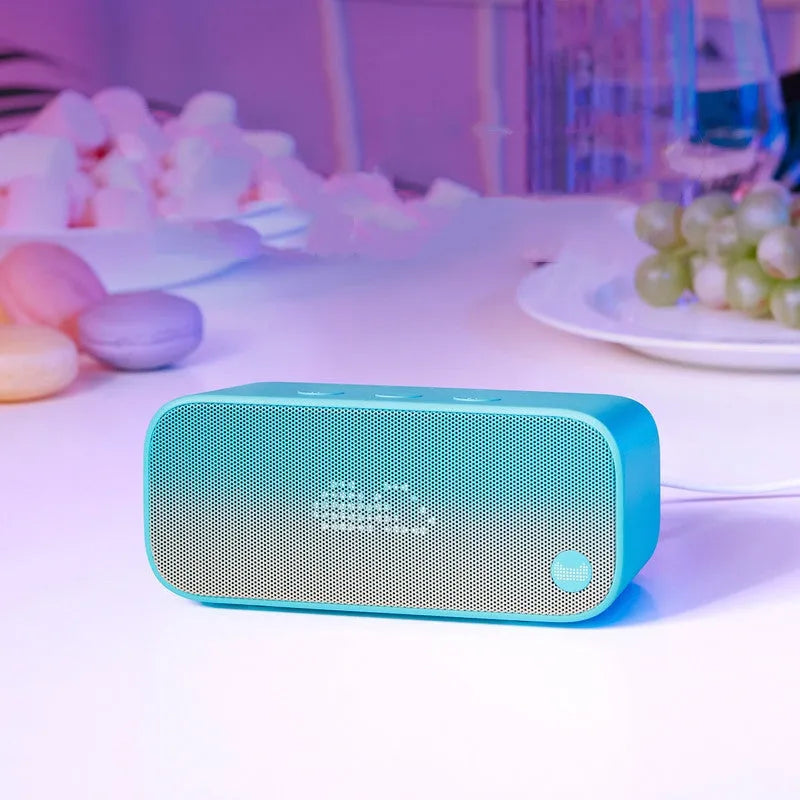 Elf Sugar Cube artificial intelligence smart WiFi speaker in blue, green, red, or white colours on a bookshelf.