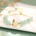 Green aventurine and strawberry quartz rabbit charm bracelet on a copper and gold chain.