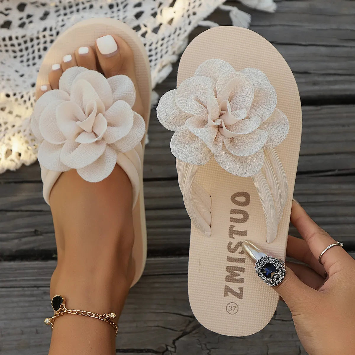 A pair of plus size floral design flip flop slippers in creamy-white with a PU upper and sole.