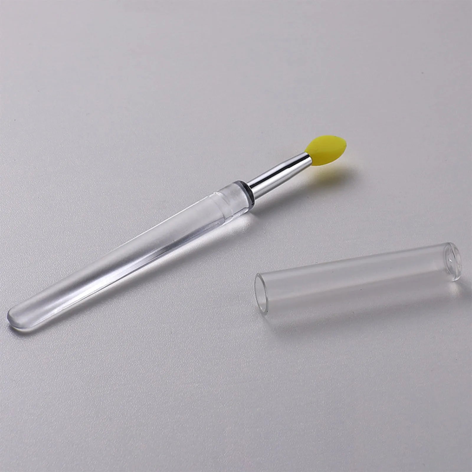 Set of four silicone lip brushes with protective caps in various colours for makeup application