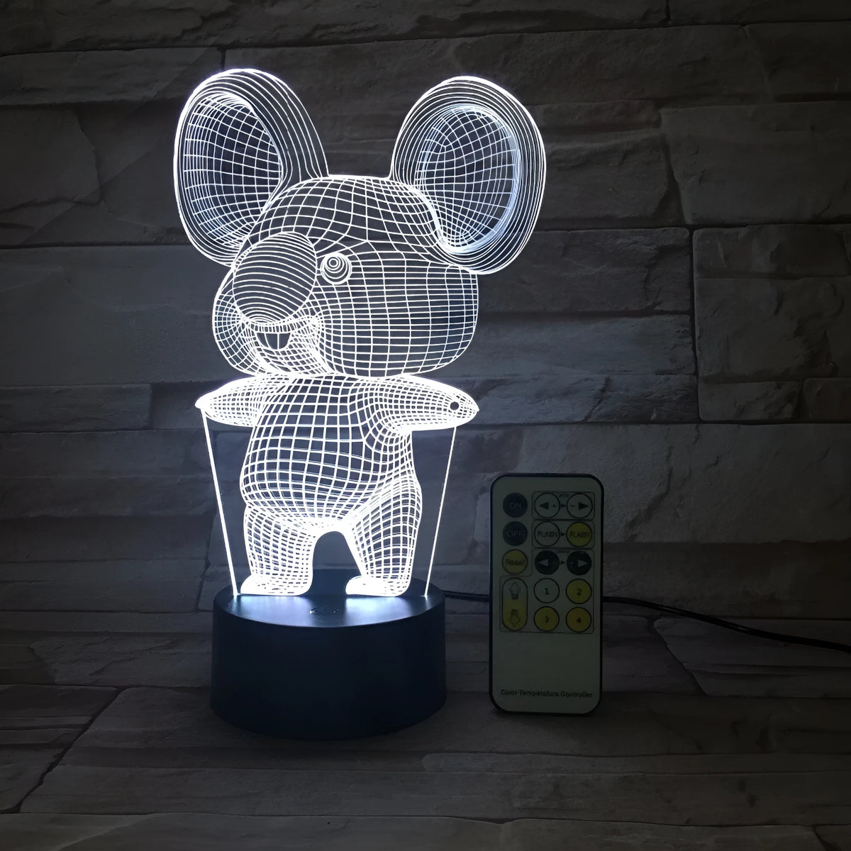 Koala-shaped LED night light with remote control on a bedside table, showing multiple colour options.