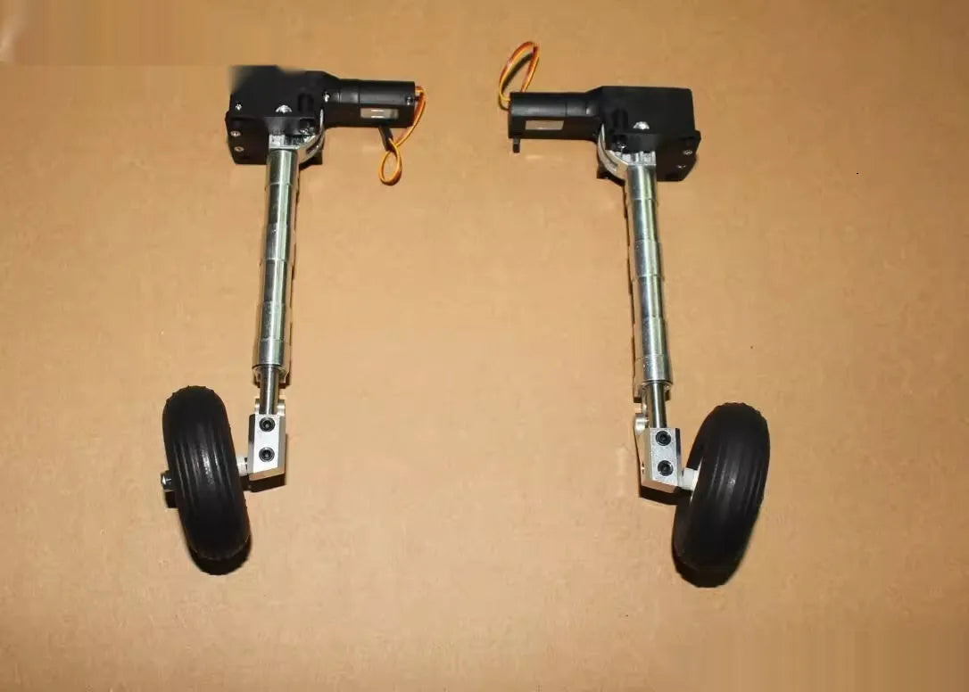Pair of silver alloy retractable landing gear with shock absorbers and black rubber wheels for RC model aircraft.