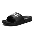 Large size men's black open toe slippers with a rubber sole, shown from the side.