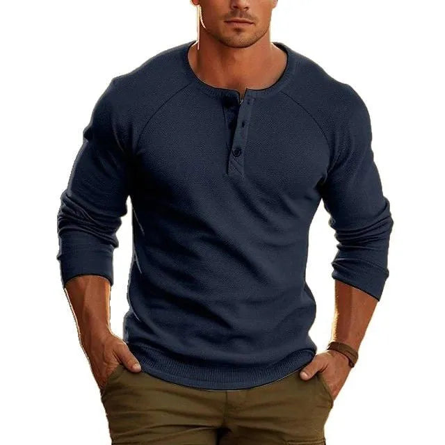 Man wearing a navy blue long-sleeved t-shirt with a Henry collar, showcasing the pullover style.