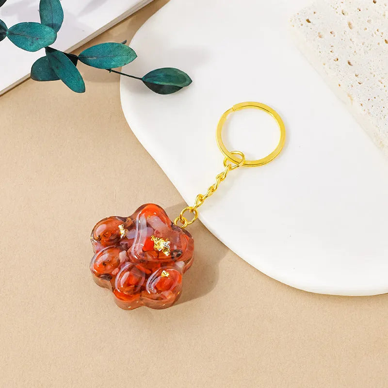 Small handcrafted crystal cat's paw shaped keychain pendant on a keyring.