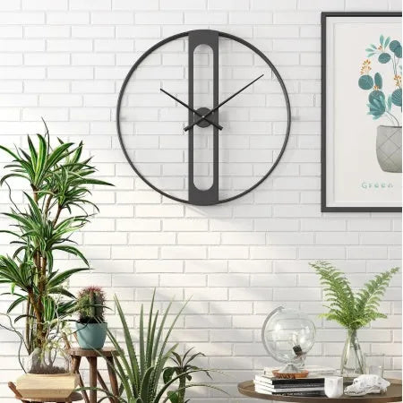 A large 50 cm round metal wall clock on a wall, available in black or gold finish.
