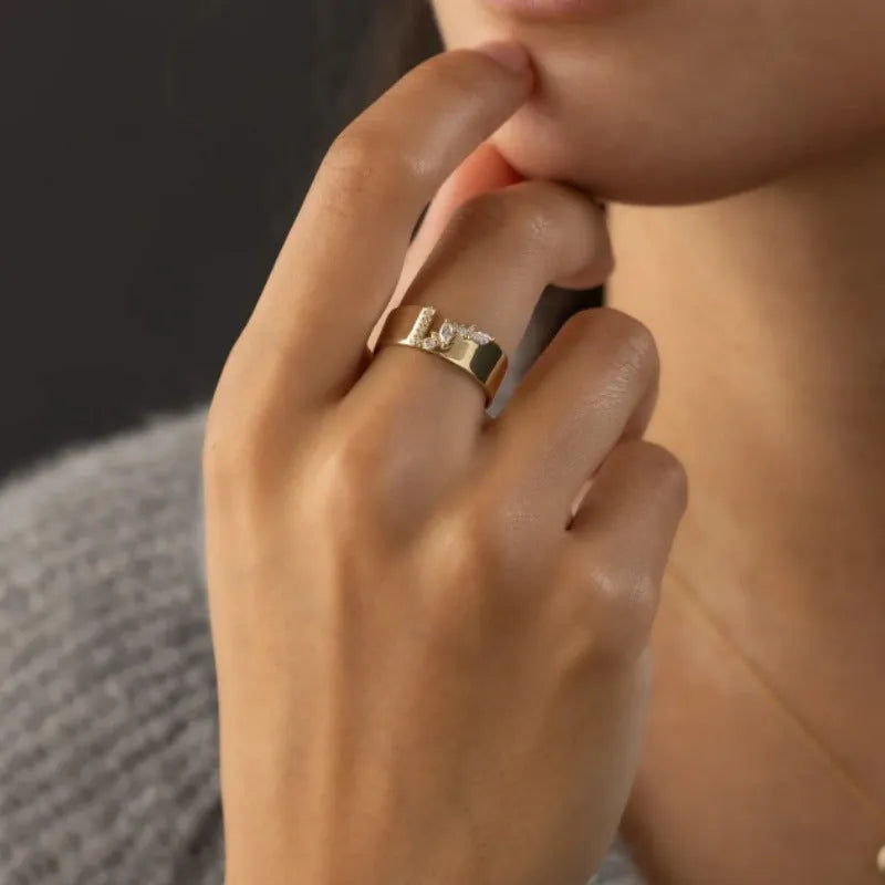 Gold electroplated zircon ring on finger, showing metallic finish and decorative elements