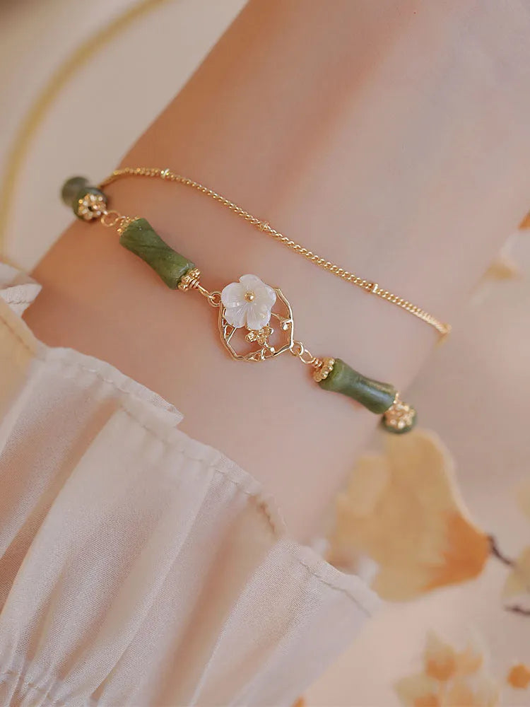 Handmade double layer olivine bracelet with Bells of Ireland charms on a model's wrist
