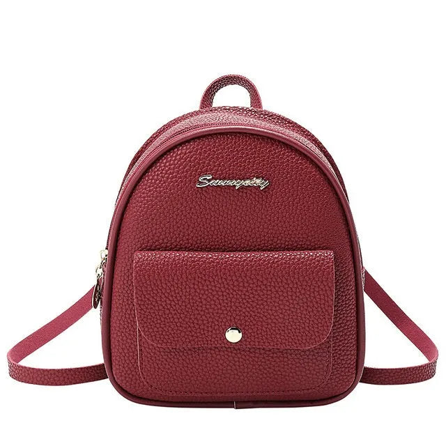 Women's small PU leather backpack shoulder bag in black showing front zipper and compact size