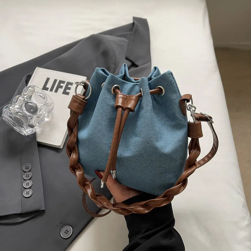 Blue synthetic leather cross-body bucket bag with sandwich pocket design