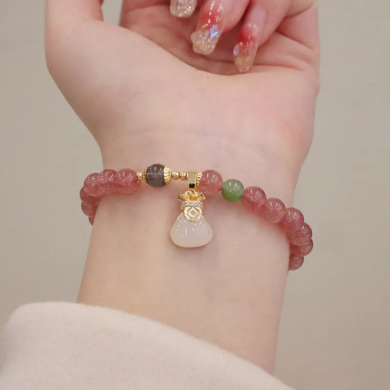 Women's strawberry quartz bracelet with geometric beads, peace buckle closure, and lucky bag charms