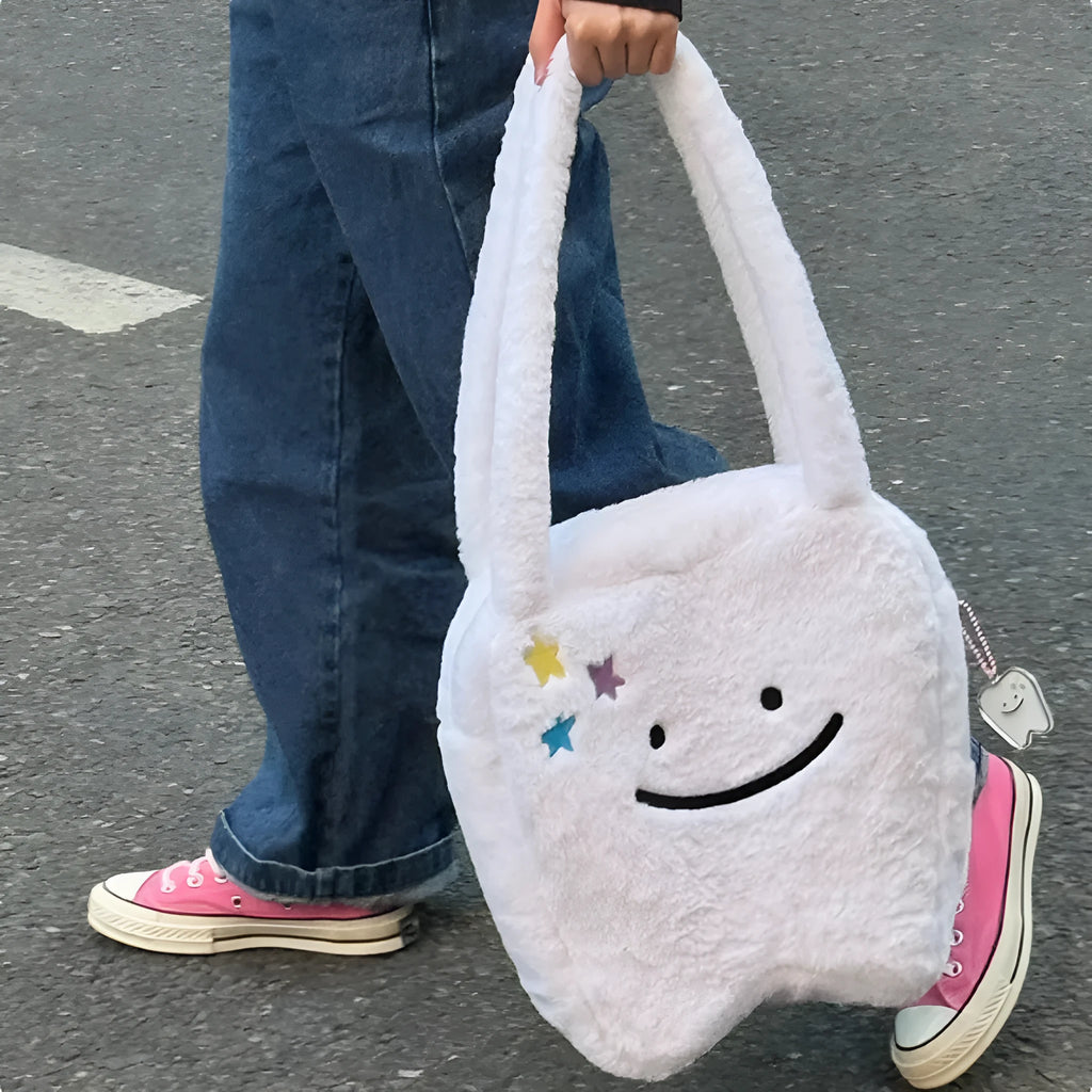 White plush tote bag with a cute teeth pattern, showing the shoulder strap and zipper closure
