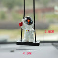 Resin astronaut car pendant showing five colour options including telescope and red flag designs