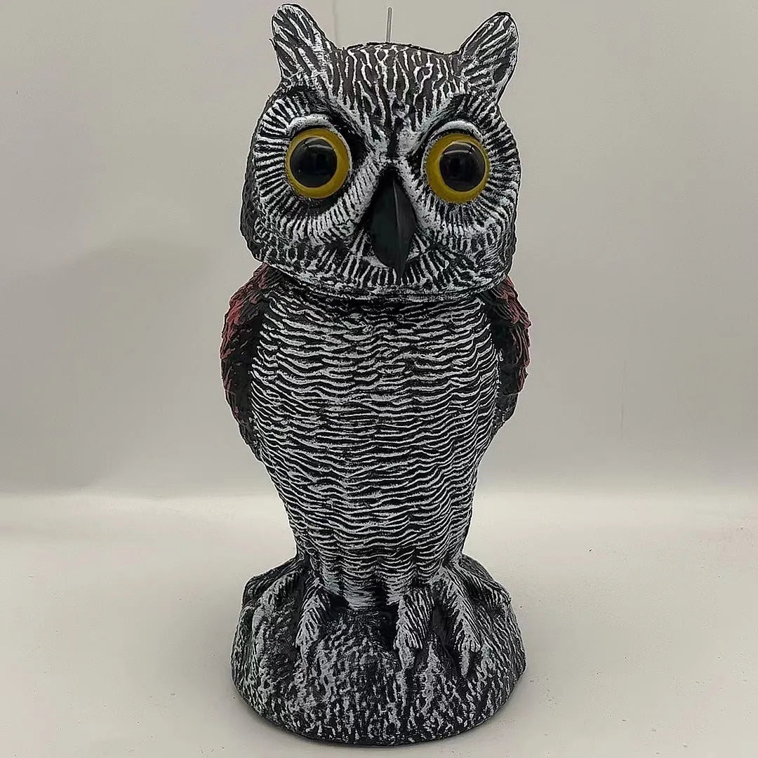 Polyethylene artificial owl bird scarer ornament with moving head, shown in a garden setting.