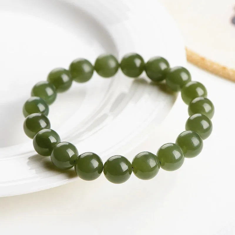 Polished Hetian jade ball bracelet showing spherical beads in ice-like clear water colour on a wrist.